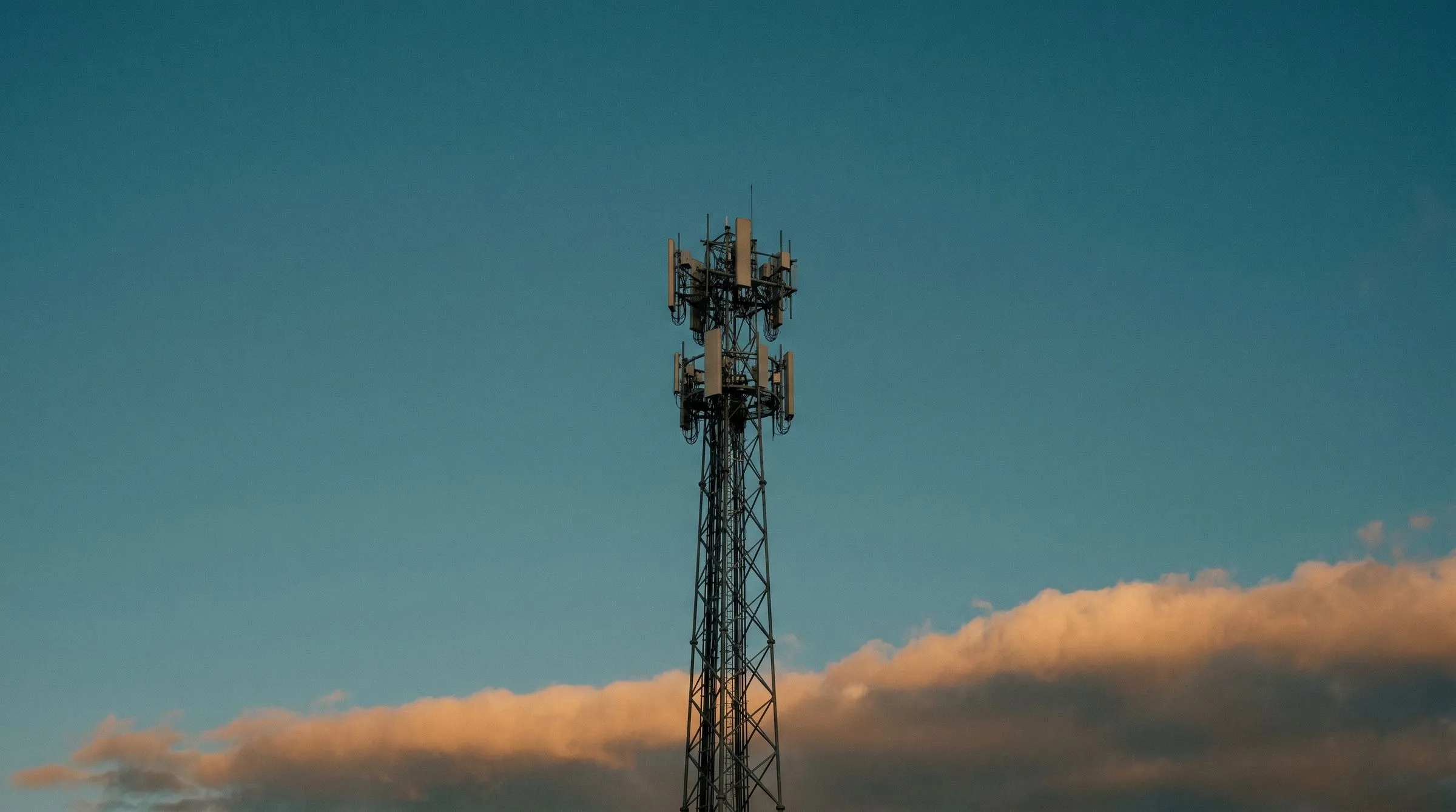 Mobilfunkmast in der Abenddämmerung — Sinnbild für die schrittweise Abschaltung des 2G-Netzes.